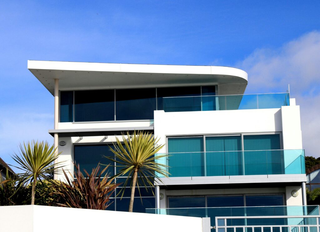 Sleek modern house with glass facade in Poole, UK under blue sky.